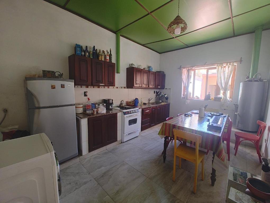 Cocina compartida del hostal con mesa, horno y heladera