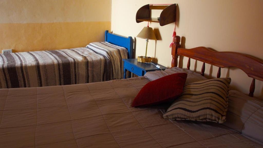 Habitación con cama matrimonial y cama individual, con luz natural