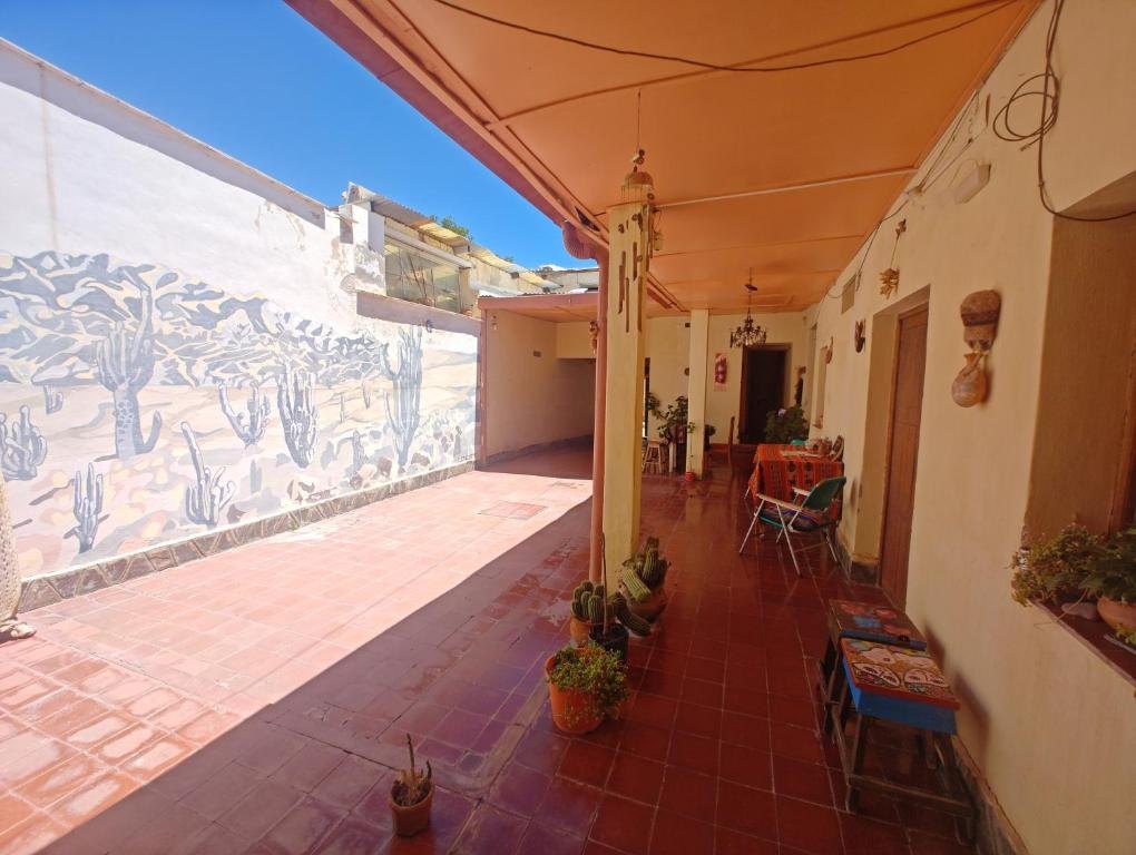 Galería del patio con piso de baldosas y un mural de la Quebrada